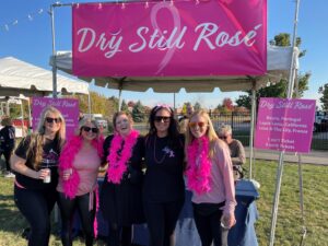Wine Off the Fox 6 women in pink boas near wine tent at Venue 102.